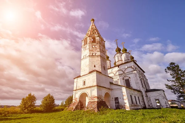 Antigua iglesia ortodoxa en la aldea. Vista de verano con pradera floral. Bengala solar — Foto de Stock