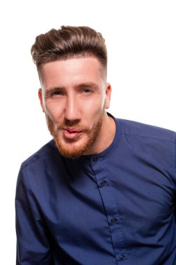 Çekici bir genç adam beyaz bir arka plan üzerinde izole mavi gömlek giymiş.
