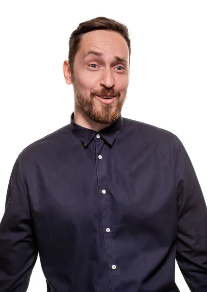 Retrato de un hombre guapo, sin afeitar, vestido con una camisa azul oscuro, de pie sobre un fondo blanco. Hombre seguro de sí mismo . — Foto de Stock