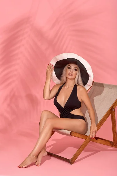 Vrouw ontspannen op de strandstoel. Zonbad met hoed, zonnebril en verschillende expressies, studio opname — Stockfoto