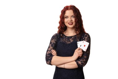 İskambil tutan genç kadın gece kıyafeti, uzun kızıl saçlı. Beyaz izole. Poker