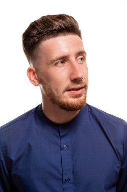 Çekici bir genç adam beyaz bir arka plan üzerinde izole mavi gömlek giymiş.