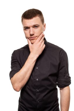 Yakışıklı genç bir siyah gömlekli yüzler, beyaz bir arka plan üzerinde izole dururken yapıyor