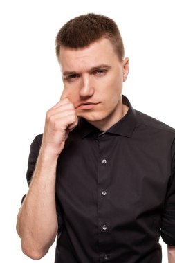 Yakışıklı genç bir siyah gömlekli yüzler, beyaz bir arka plan üzerinde izole dururken yapıyor