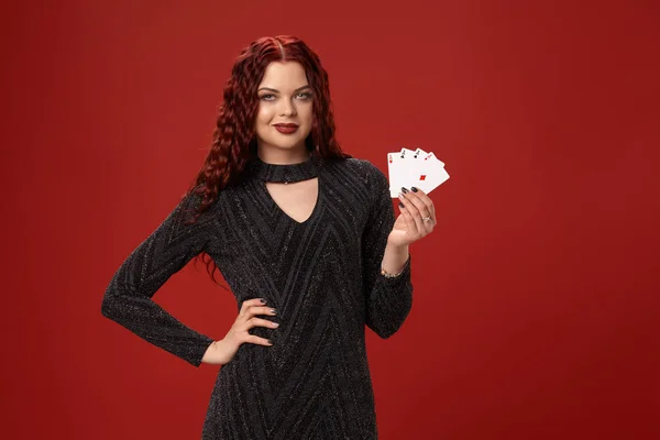 Bella donna dai capelli rossi sta tenendo alcune carte da gioco. Casino — Foto Stock