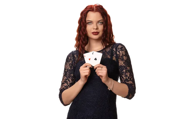 Νεαρή γυναίκα με μια μακριά κόκκινα μαλλιά στο βραδινό ντύσιμο, κρατώντας παίζοντας χαρτιά. Απομονωμένα σε λευκό. Πόκερ — Φωτογραφία Αρχείου