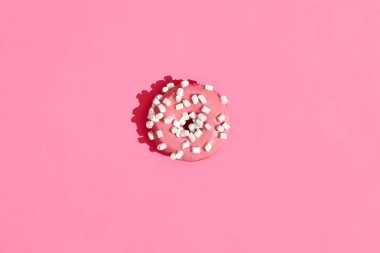 Gıda tasarım. Yüksek kaliteli görüntü mercan pembe bir arka plan üzerinde pembe sırlı donut kapatın