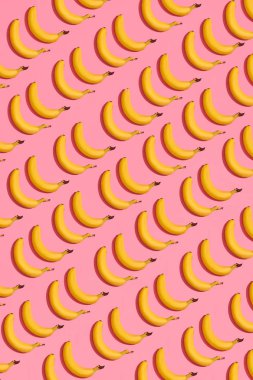 Pembe bir arka plan yanında, üstten görünüm yalan sarı tatlı muz desen kompozisyonu