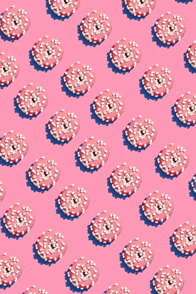 Diseño de alimentos con sabroso rosado esmaltado donut en coral rosa pastel fondo superior ver patrón —  Fotos de Stock