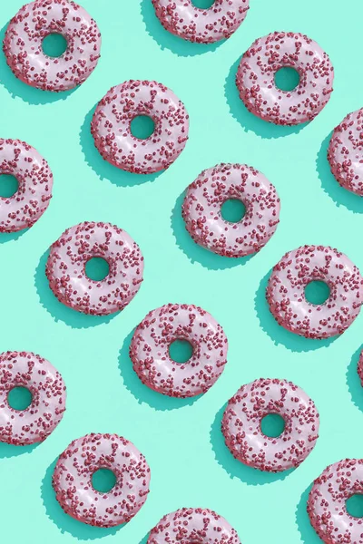 トップ ビューのアクアマリン グリーン ブルー パステル背景パターンにおいしいピンクの艶をかけられたドーナツとフード デザイン — ストック写真