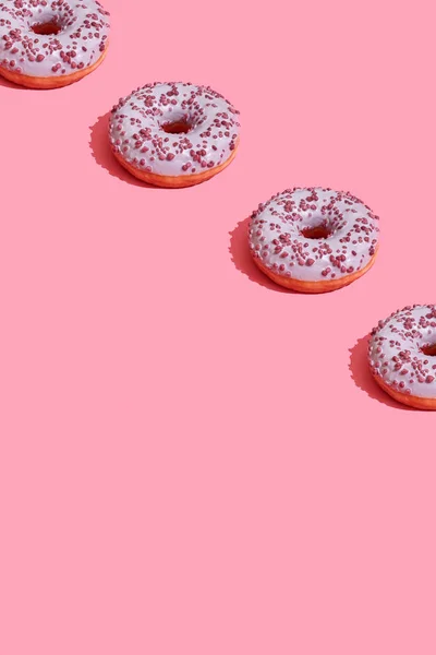 トップ ビューのコーラル ピンク パステル背景パターンにおいしいピンクの艶をかけられたドーナツとフード デザイン — ストック写真
