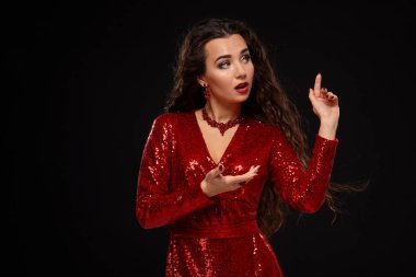 Sevimli genç beyaz esmer kadın kamera Studio siyah arka plan üzerine önce poz kırmızı kokteyl elbiseli