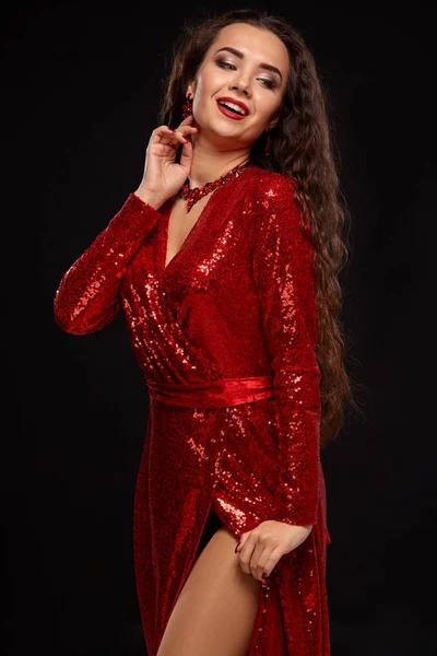 Okouzlující mladá kavkazské brunetka žena v červené koktejlové šaty pózování před kamerou na černém pozadí — Stock fotografie