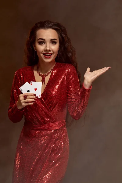 빨간 이브닝 드레스에 젊은 아름 다운 행운 갈색 머리 그녀의 카드, 에이스의 쌍을 보여줍니다. — 스톡 사진