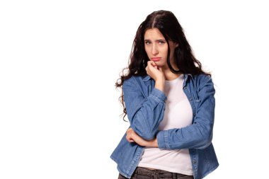 Yüzünde ciddi bir ifade ile kameraya bakarak koyu dalgalı saçlı güzel ve mutsuz genç kadın.