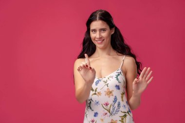 Gülümseyen ciddi kız işaret parmağını önünde tutarak, şöyle diyor: Hey, bir dakika