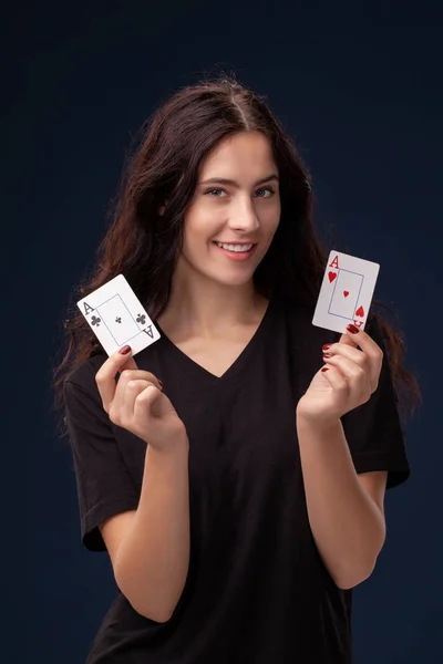 彼女の手にトランプでポーズ巻き毛ブルネットのクローズアップショット。黒の背景にポーカーの概念。カジノ. — ストック写真