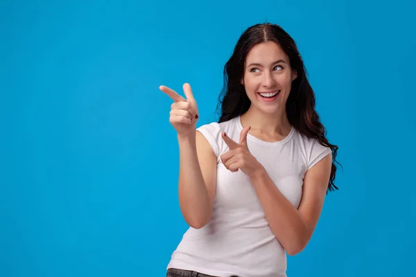 Woman making gun gesture on blue background — 스톡 사진