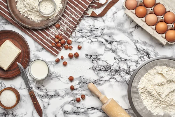 Primer plano de tiro. Vista superior de los ingredientes para hornear y utensilios de cocina sobre el fondo de la mesa de mármol . — Foto de Stock