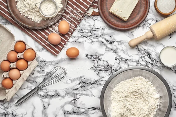 Närbild skott. Top utsikt över en bakning ingredienser och köksartiklar på marmor bordsbakgrund. — Stockfoto