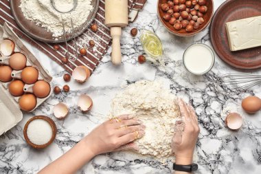 Yakın çekim. Bir fırıncı yemek yeri üst görünümü, eller mermer masa arka plan üzerinde ham bir hamur ile çalışıyoruz.
