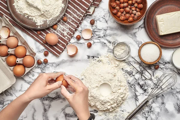 Um plano de perto. Vista superior de um local de cozinheira padeiro, as mãos estão trabalhando com uma massa crua no fundo da mesa de mármore . — Fotografia de Stock