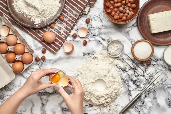 Um plano de perto. Vista superior de um local de cozinheira padeiro, as mãos estão trabalhando com uma massa crua no fundo da mesa de mármore . — Fotografia de Stock