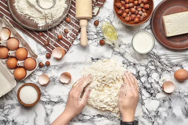 Um plano de perto. Vista superior de um local de cozinheira padeiro, as mãos estão trabalhando com uma massa crua no fundo da mesa de mármore . — Fotografia de Stock