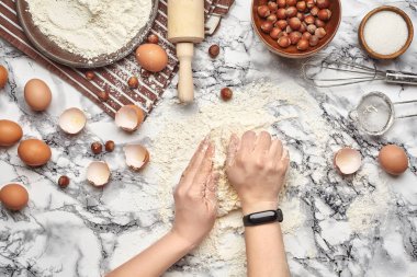 Yakın çekim. Bir fırıncı yemek yeri üst görünümü, eller mermer masa arka plan üzerinde ham bir hamur ile çalışıyoruz.