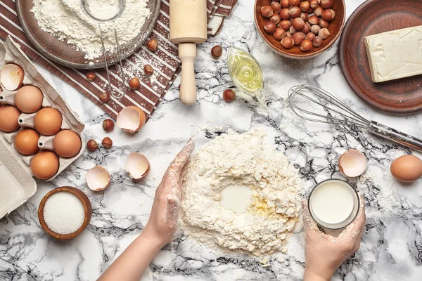 Nahaufnahme. Blick von oben auf einen Backofen, Hände arbeiten mit einem rohen Teig auf dem Marmortischhintergrund. — Stockfoto