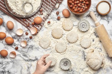 Yakın çekim. Bir fırıncı yemek yeri üst görünümü, eller mermer masa arka plan üzerinde ham bir hamur ile çalışıyoruz.
