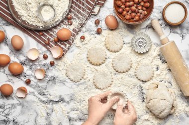 Yakın çekim. Bir fırıncı yemek yeri üst görünümü, eller mermer masa arka plan üzerinde ham bir hamur ile çalışıyoruz.
