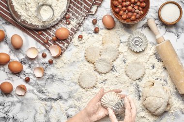 Yakın çekim. Bir fırıncı yemek yeri üst görünümü, eller mermer masa arka plan üzerinde ham bir hamur ile çalışıyoruz.