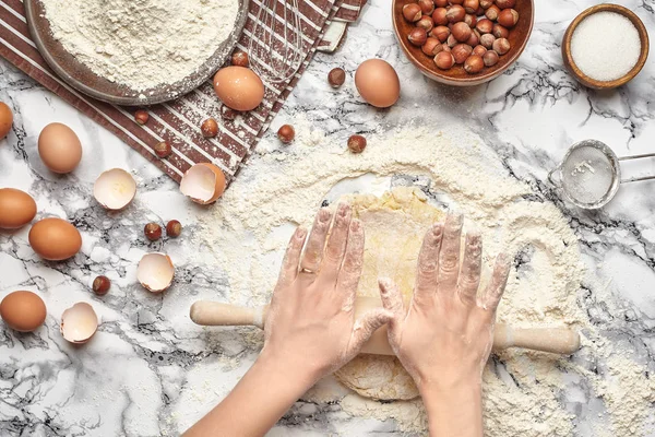 Primer plano de tiro. Vista superior de un lugar de cocción panadero, las manos están trabajando con una masa cruda sobre el fondo de la mesa de mármol . — Foto de Stock
