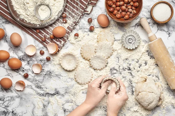 Um plano de perto. Vista superior de um local de cozinheira padeiro, as mãos estão trabalhando com uma massa crua no fundo da mesa de mármore . — Fotografia de Stock