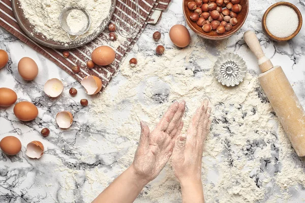 Um plano de perto. Vista superior de um local de cozinheira padeiro, as mãos estão trabalhando com uma massa crua no fundo da mesa de mármore . — Fotografia de Stock