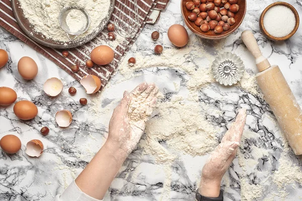 Yakın çekim. Bir fırıncı yemek yeri üst görünümü, eller mermer masa arka plan üzerinde ham bir hamur ile çalışıyoruz. — Stok fotoğraf