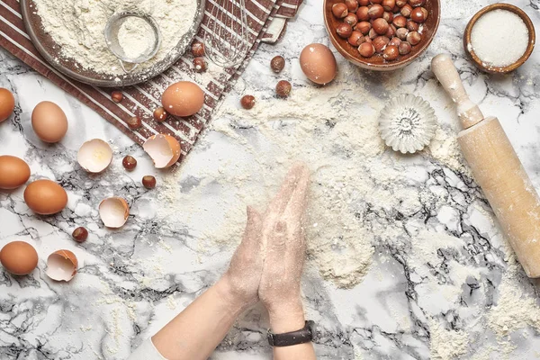 Um plano de perto. Vista superior de um local de cozinheira padeiro, as mãos estão trabalhando com uma massa crua no fundo da mesa de mármore . — Fotografia de Stock