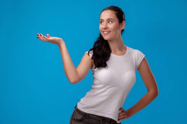 Mavi duvar arka plan karşı beyaz bir t-shirt genç bir güzel kadının Stüdyo portresi. İnsanlar samimi duygular.