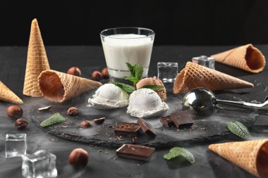 Gurme çikolata ve krem dondurma siyah bir arka plan üzerinde bir taş kayrak üzerinde servis.