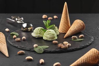 Gurme antep fıstığı dondurma siyah bir arka plan üzerinde bir taş kayrak üzerinde servis.