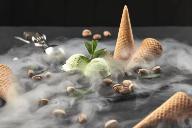 Gurme çikolata ve antep fıstığı dondurma siyah bir arka plan üzerinde bir taş kayrak üzerinde servis.