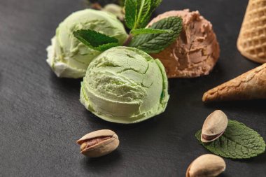 Gurme çikolata ve antep fıstığı dondurma siyah bir arka plan üzerinde bir taş kayrak üzerinde servis.