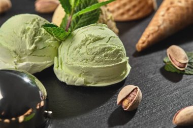 Gurme çikolata ve antep fıstığı dondurma siyah bir arka plan üzerinde bir taş kayrak üzerinde servis.