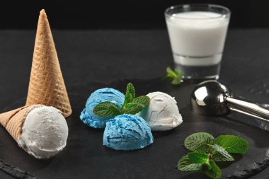 Koyu bir sayfa üzerinde servis edilen kremsi ve yaban mersini dondurmayakın çekim, siyah arka plan.