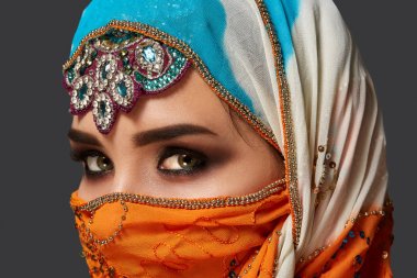 Payet ve takıile süslenmiş renkli başörtüsü giyen bir chrming kadın Stüdyo çekim. Arap tarzı.
