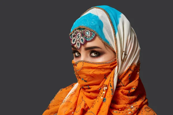 Studio shot of a chrming female wearing the colorful hijab decorated with sequins and jewelry. Arabic style. — Stock Photo, Image