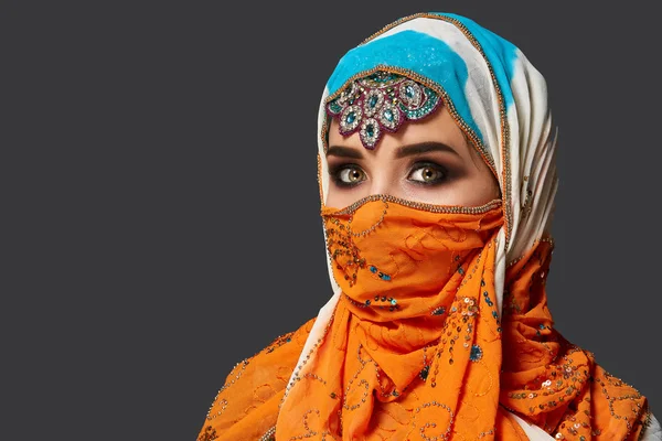 Studio skott av en chrming kvinna klädd i färgglada hijab dekorerad med paljetter och smycken. Arabisk stil. — Stockfoto