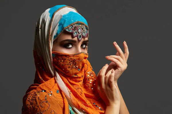 スパンコールとジュエリーで飾られたカラフルなヒジャーブを身に着けた、クリングの女性のスタジオショット。アラビアスタイル. — ストック写真