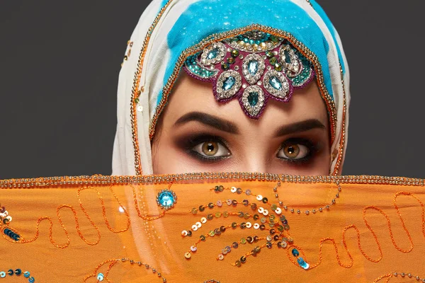 Estúdio tiro de uma fêmea chrming vestindo o hijab colorido decorado com lantejoulas e jóias. Estilo árabe . — Fotografia de Stock